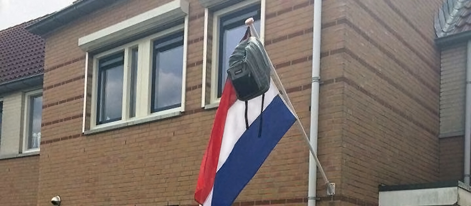 schoolbag hanging on Dutch flagpole