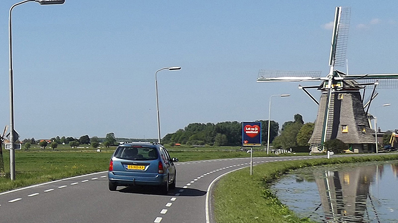 bring a car to Netherlands - car driving near Dutch windmill
