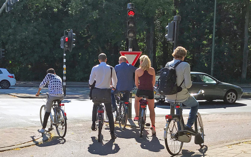 Netherlands cycling guidelines - bicycle riders stopped at traffic light in The Hague Netherlands
