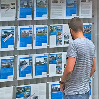 buyer looking at homes for sale in Dutch real estate agent makelardij office window